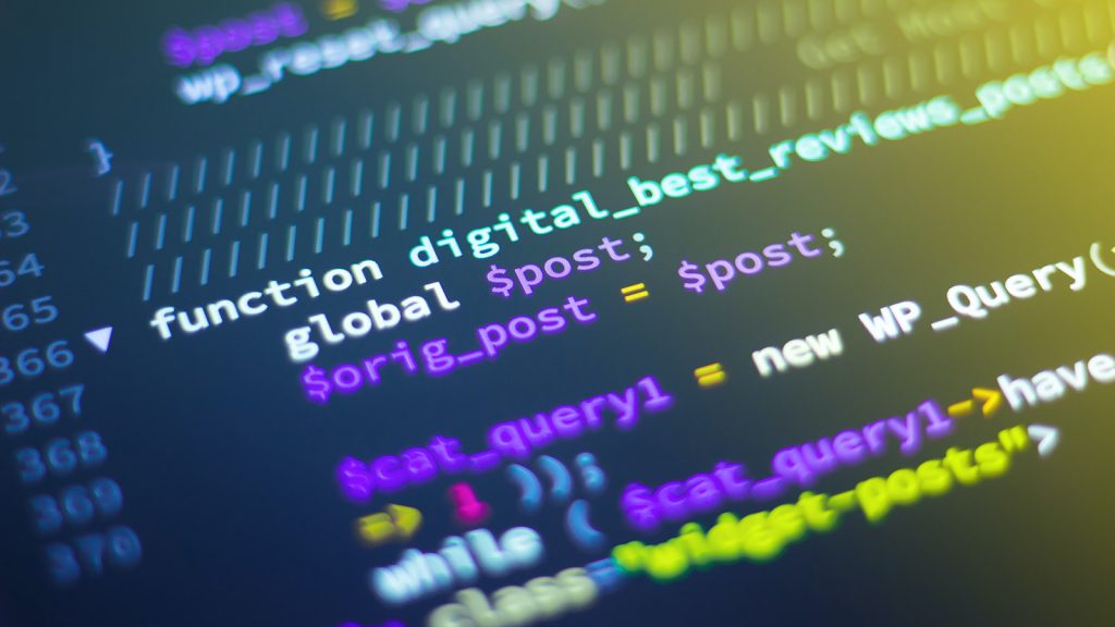 Detailausschnitt aus Computercode, der in bunten Lettern auf einem schwarzen Bildschirm angezeigt wird.