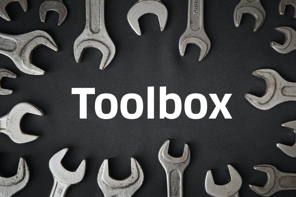 Mehrere Schraubenschlüssel, die rund angeordnet um eine freie Mitte angeordnet sind. In der Mitte steht das Wort Toolbox.