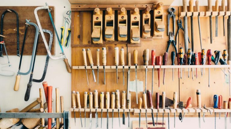 Werkzeuge hängen in einer Werkstatt an einer Holzwand
