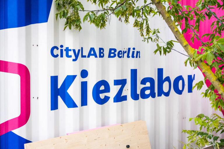weißer Schisscontainer mit blau-pinker Aufschrift CityLAB Berlin Kiezlabor