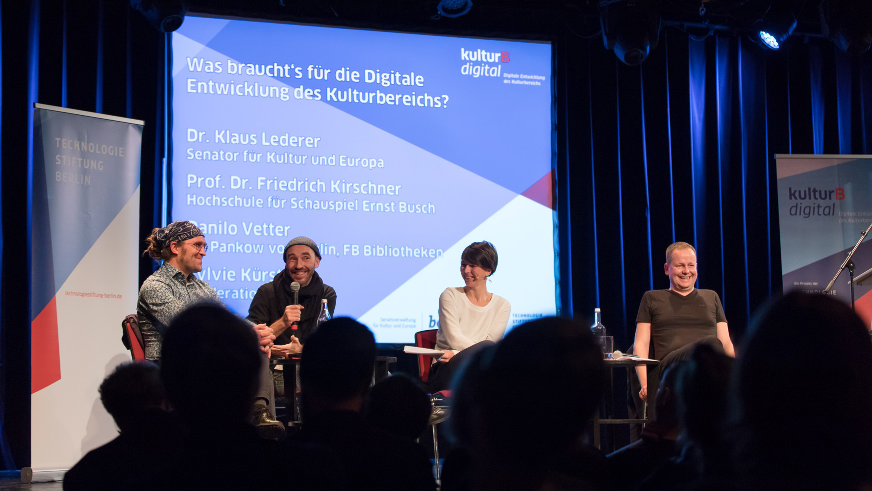 Diskussionsrunde mit heiter lachenden Gästen auf der kulturBdigital Konferenz