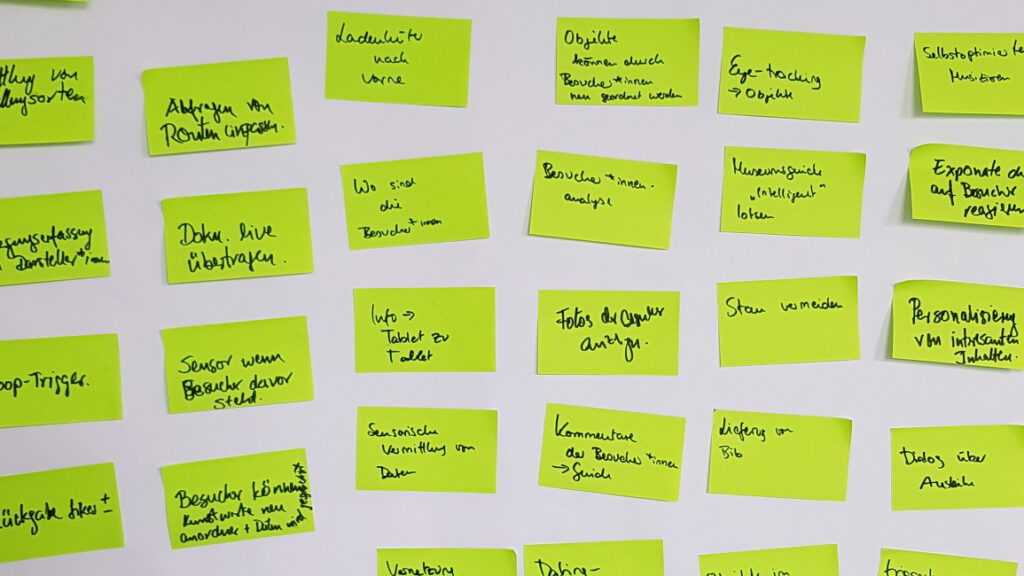Brainstorming zum Einsatz von IoT Technologie: Grüne Klebezettel sind in Reihen arrangiert.