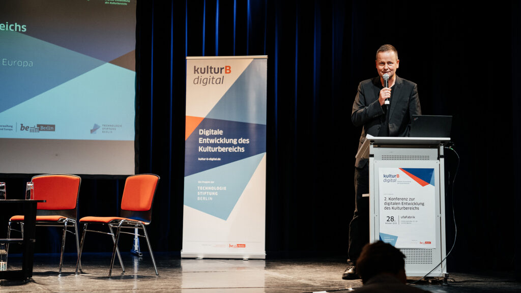 Kultursenator Klaus Lederer spricht am Pult auf der kulturBdigital-Konferenz.