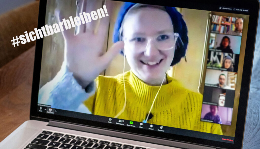 Susanne Schuster winkt Festival-Teilnehmer:innen entgegen. Alle sind auf einem Laptop in Videokonfernzschalte zu sehen.