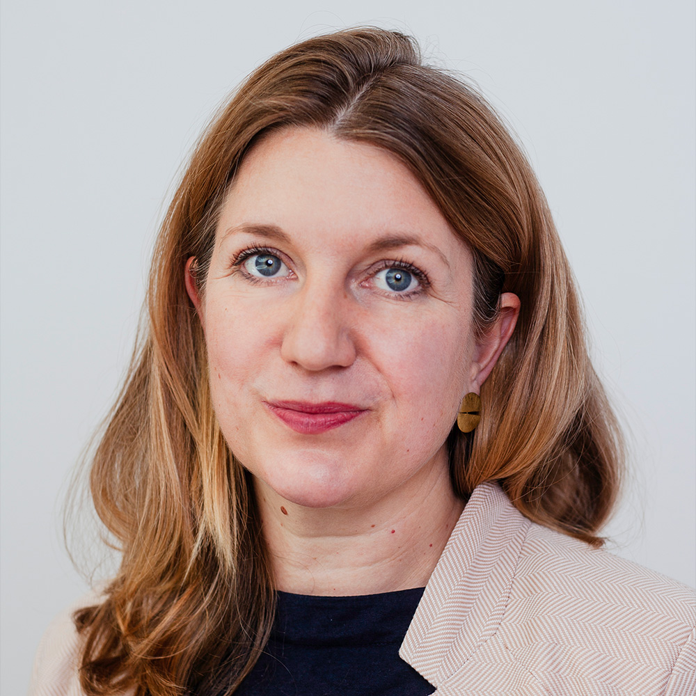 Porträt von Dr. Julia Pohle vor blauem Hintergrund