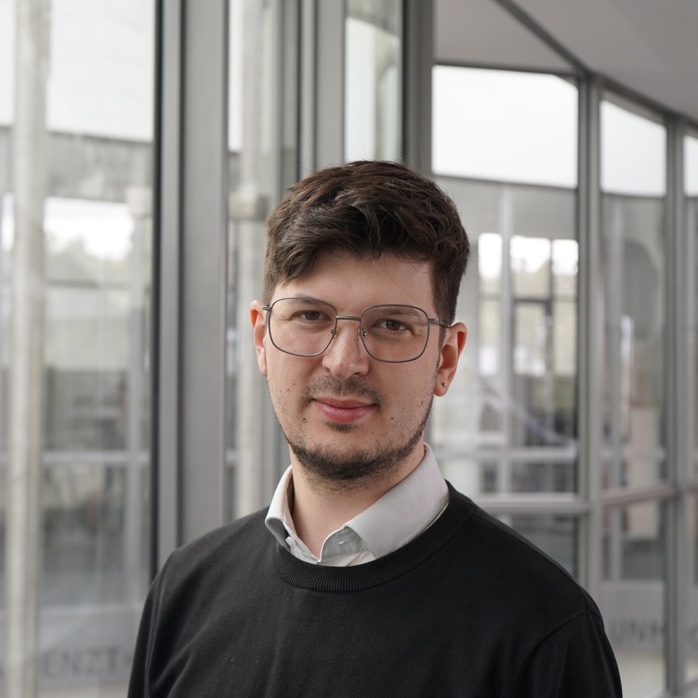 Porträt von Lasse Kohlmeyer vor einer Glasfront
